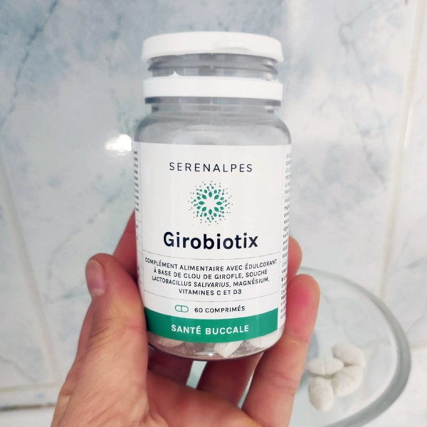 Flacon Girobiotix Serenalpes dans une main dans une salle de bain Flacon Girobiotix Serenalpes dans une main dans une salle de bain